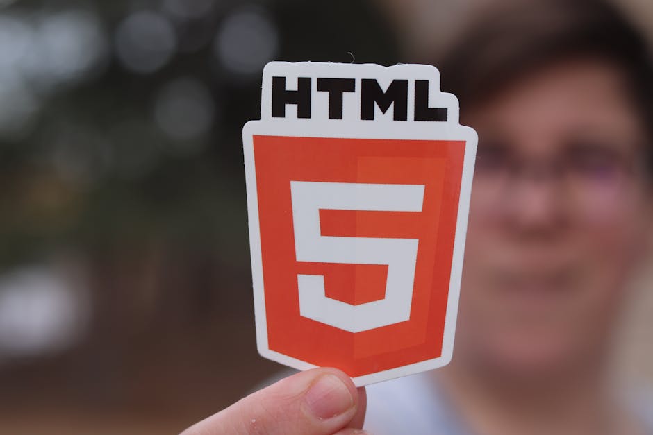A close-up photograph of a computer screen displaying a code editor with HTML code visible. The code includes tags such as <doctype html>, <html>, <head>, <meta>, <title>